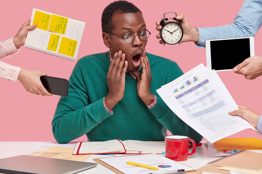 african-american-man-sitting-desk-surrounded-with-gadgets-papers-1024x682 6 Dangers of Lacking Financial Literacy