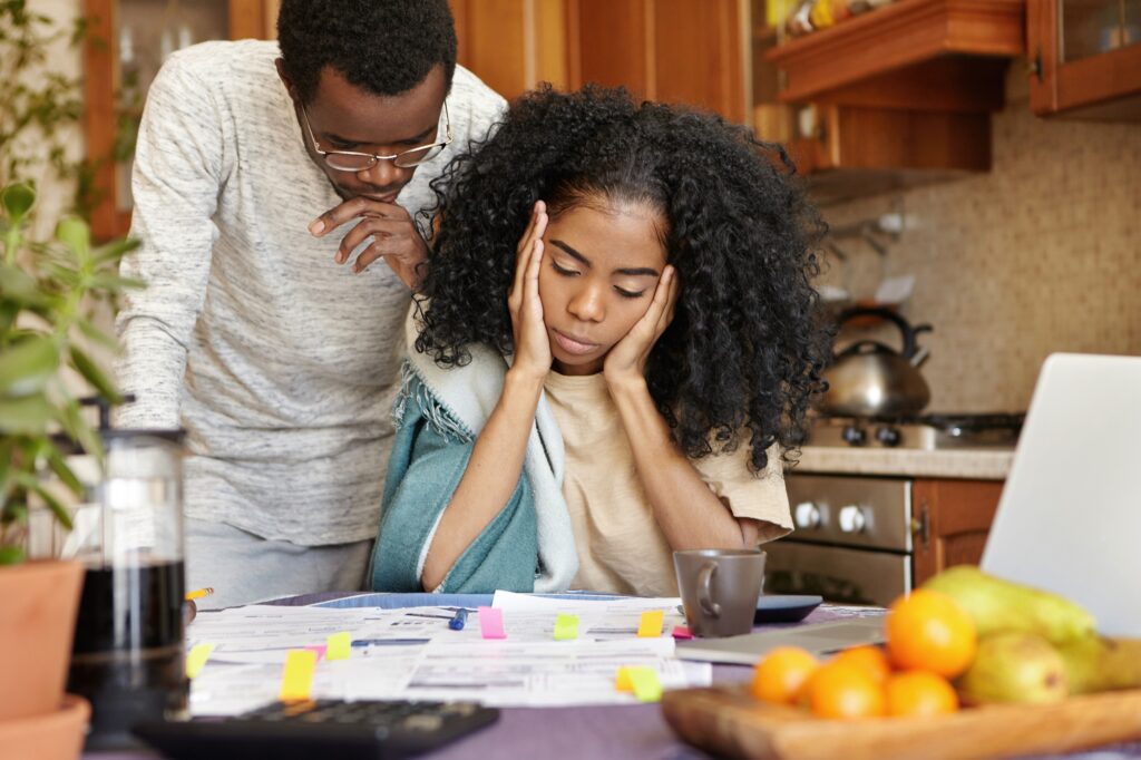 unhappy-young-african-could-looking-stressed-depressed-while-calculating-bills-home-1024x682 6 Dangers of Lacking Financial Literacy