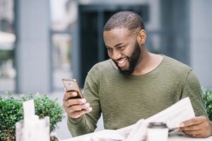 happy-man-using-smartphone-cafe-300x200 About us.