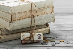 old-white-books-with-money-coins-wooden-background-300x200 About us.