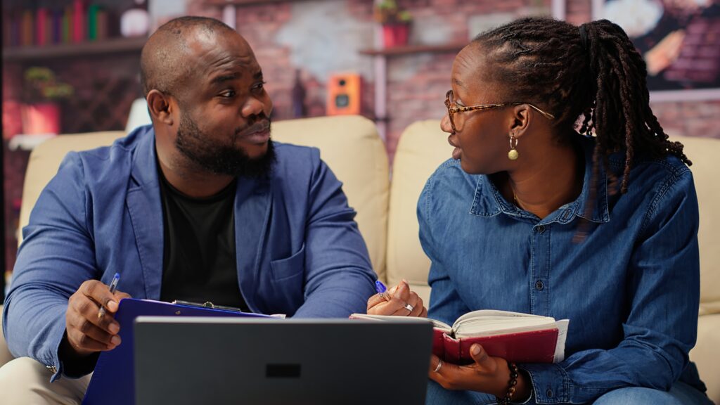 black-man-woman-writing-report-with-information-from-notebook-1024x576 URRO and the Future of Royalties in Uganda’s Creative Economy
